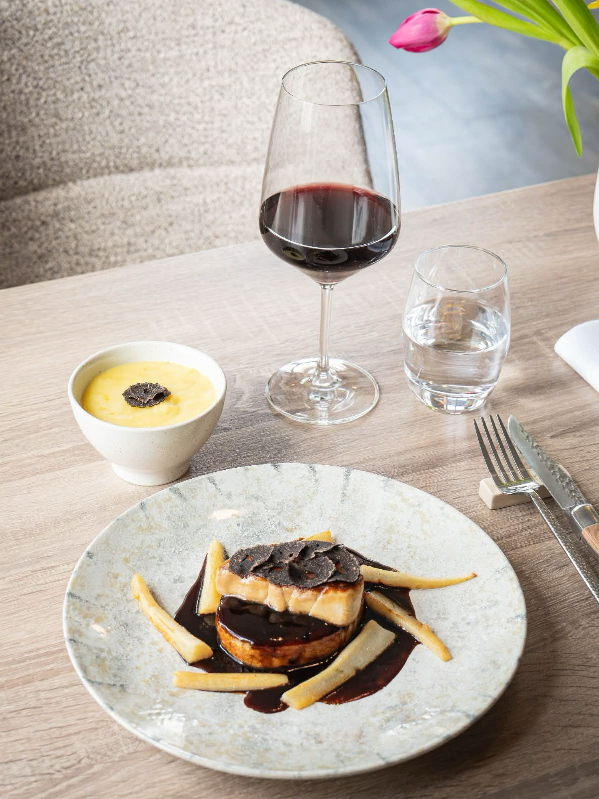 Assiette gastronomique et verre de vin rouge servis au restaurant de la Maison Jenny